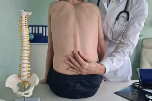 ortopeda sprawdzający kręgosłup chłopca