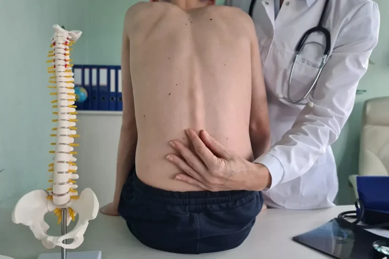 ortopeda sprawdzający kręgosłup chłopca